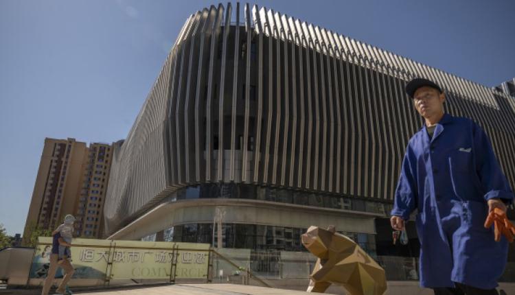 人们走过北京恒大城市广场购物中心的一座熊状雕塑 人们走过北京恒大城市广场购物中心的一座熊状雕塑