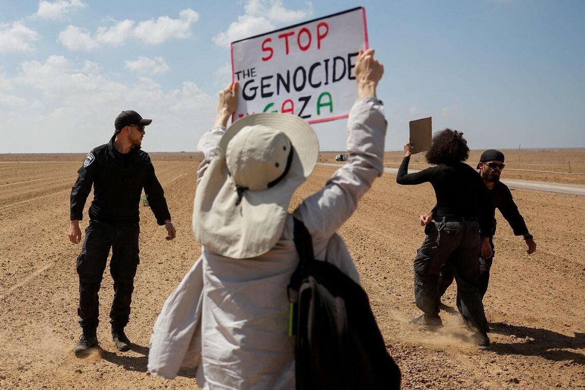 以色列警察在以色列和加沙地带边境阻止民众参加抗议活动，示威者举着的牌子写道“停止在加沙的种族灭绝行动 ...