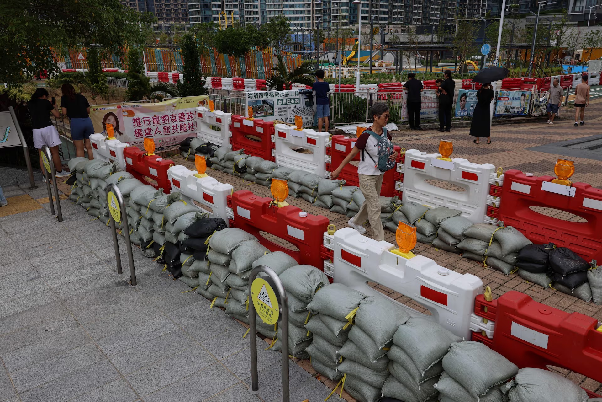 居民走过为防止超强台风桦加沙造成洪水而放置的沙袋