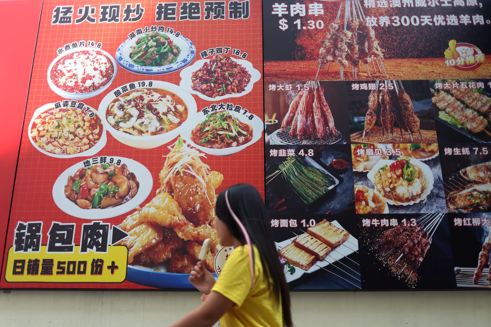 一名女子经过新加坡市中心梁城街一家中餐馆的广告